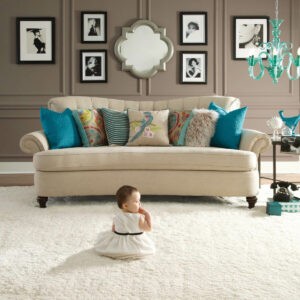 Cute baby sitting on carpet floor | Hubbard Flooring Studio